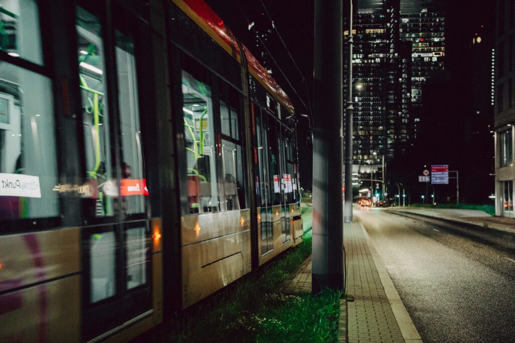 Photo of a tram in Warsaw during late evening hours.