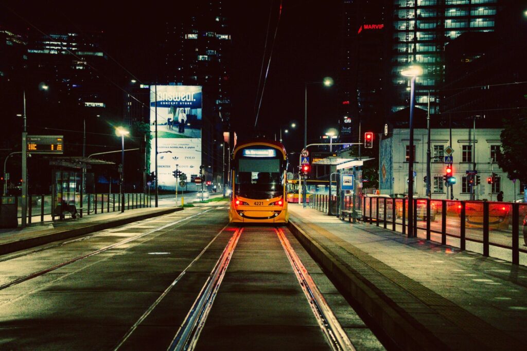 A photo of a tram at night, taken from the back with a symmetry in mind. 