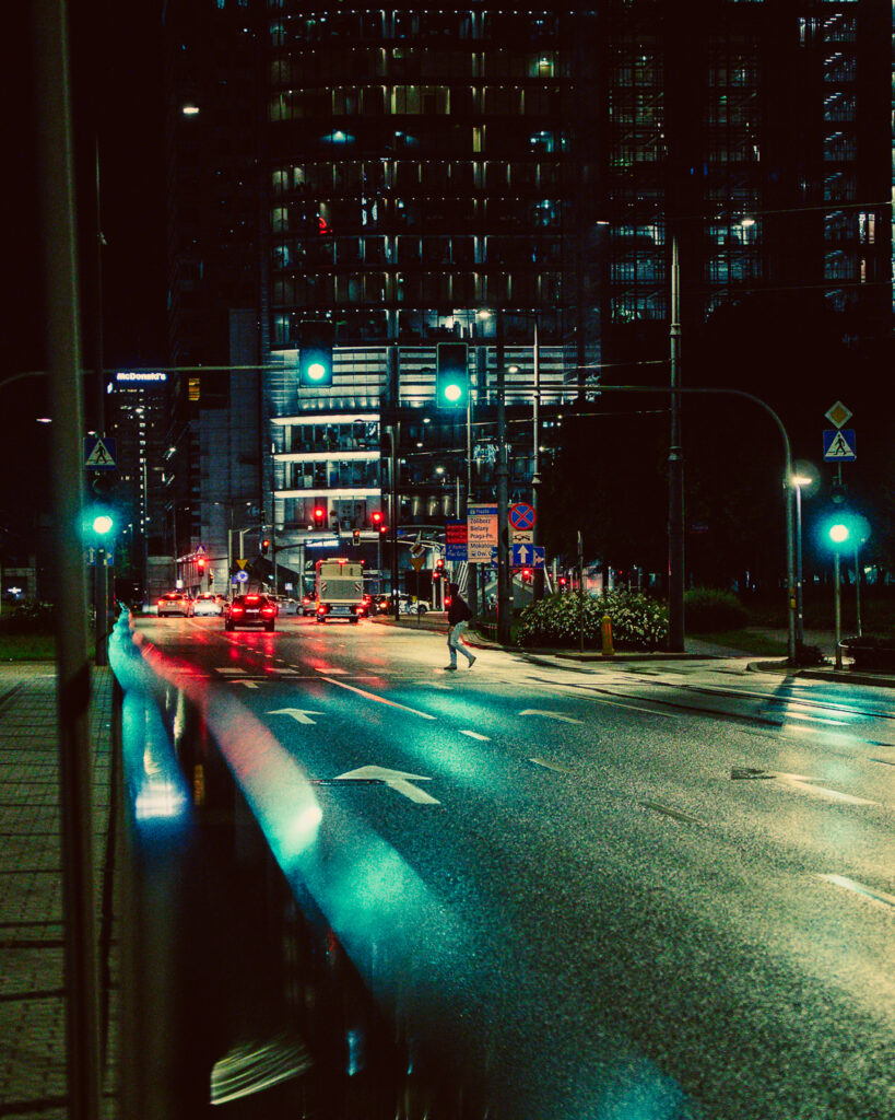 A photo of a man crossing the street in Warsaw.