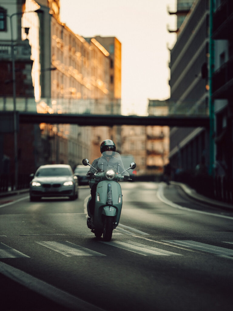A photo of an older woman on a scooter.
