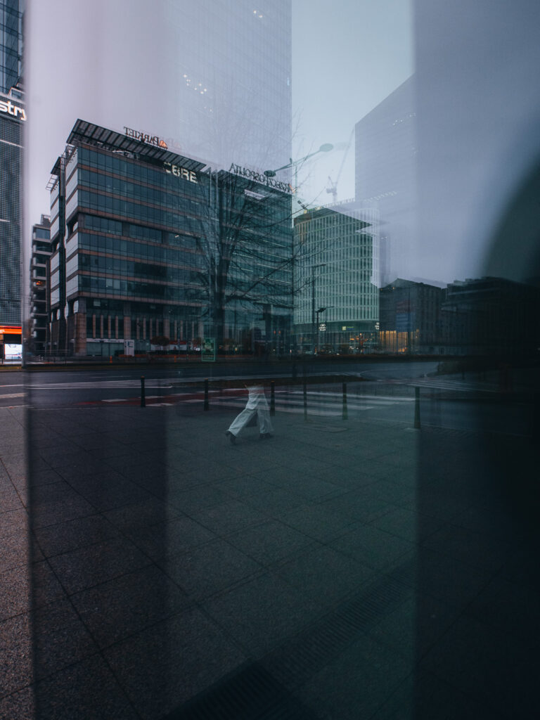 Through the window photo of a woman walking on the sidewalk.
