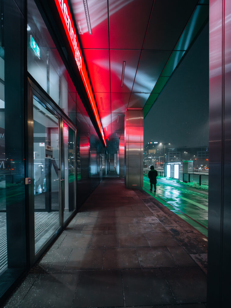 A dark silhouette walking on the snowy street.