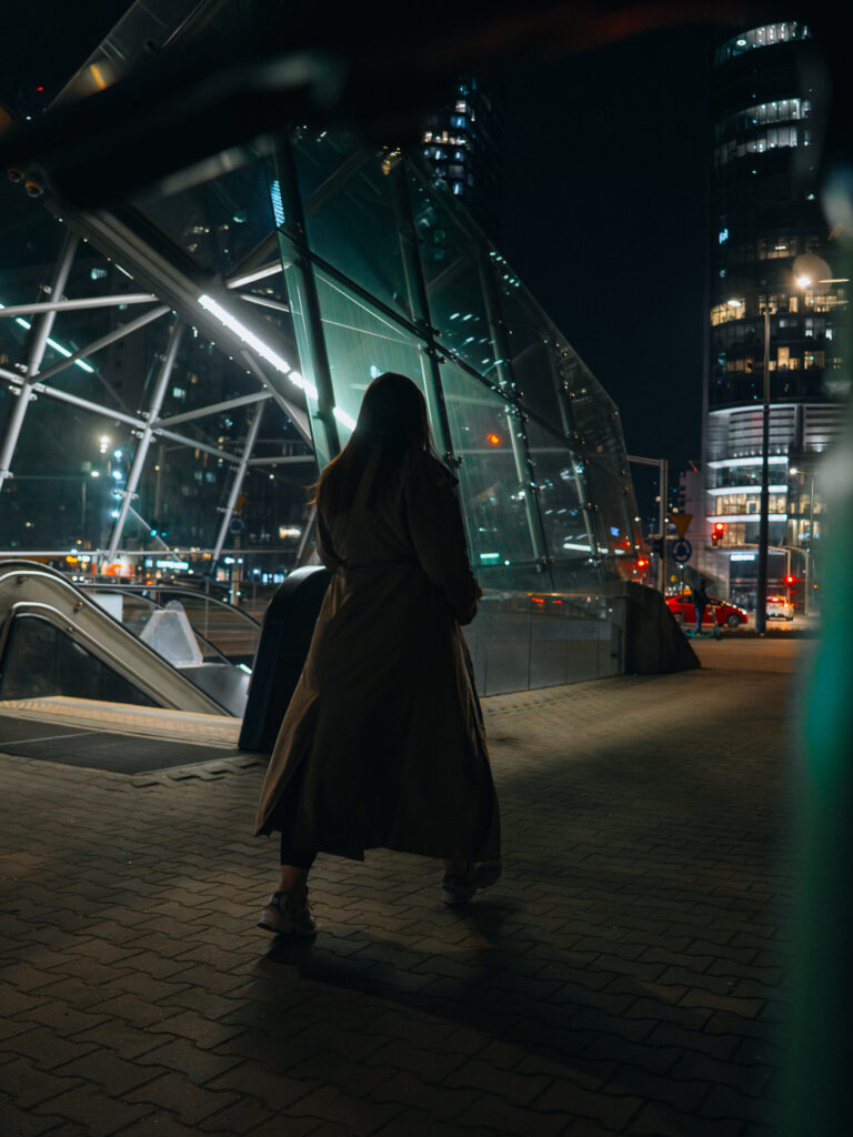 A woman walking near the metro entry.