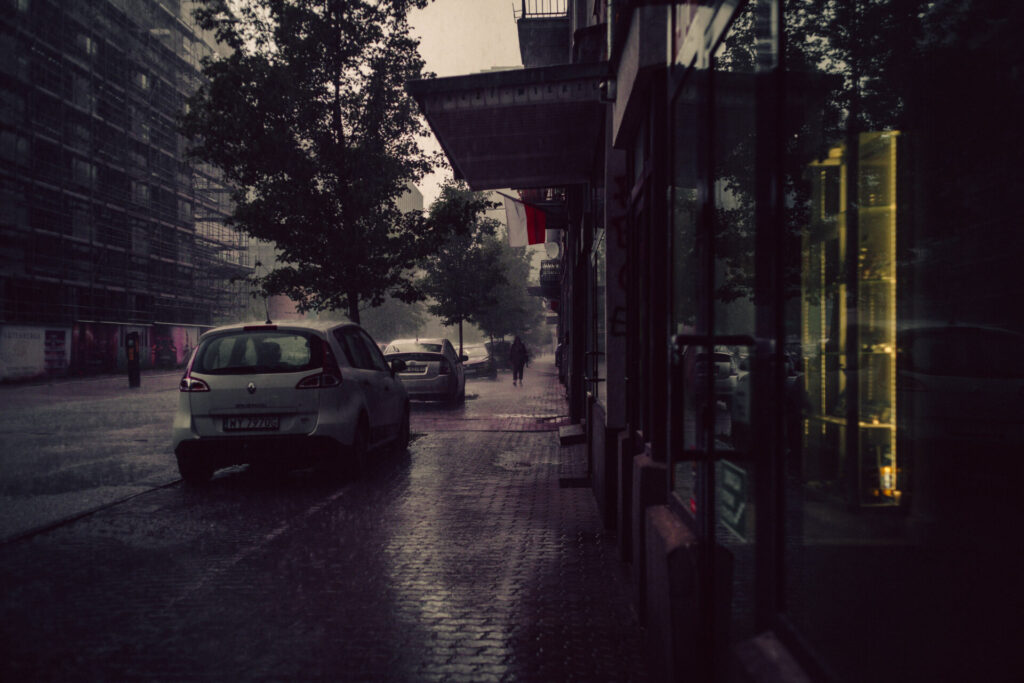 A dark silhouette walking on the street during rain. 
